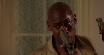 Movie still from “Jason's Lyric” (1994), directed by Doug McHenry – A man holding a gun up to his face; Close Up shot, Over the shoulder angle
