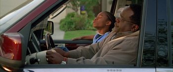 Movie still from “Johnson Family Vacation” (2004), directed by Christopher Erskin – A man and a woman sitting in the drivers seat of a car; Close Up shot, Low angle
