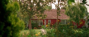 Movie still from “Johnson Family Vacation” (2004), directed by Christopher Erskin – A red house sitting in the middle of a green field; Extreme Wide shot, High angle