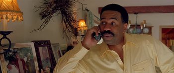 Movie still from “Johnson Family Vacation” (2004), directed by Christopher Erskin – A man talking on a cell phone while wearing a yellow shirt; Close Up shot, High angle