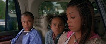 Movie still from “Johnson Family Vacation” (2004), directed by Christopher Erskin – A woman and two children sitting in the back of a car; Close Up shot, High angle