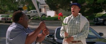 Movie still from “Johnson Family Vacation” (2004), directed by Christopher Erskin – An older man holding a rose in a street; Medium shot, Low angle