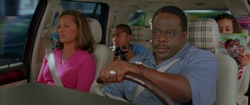 Movie still from “Johnson Family Vacation” (2004), directed by Christopher Erskin – Three people in the back seat of a car; Medium shot, High angle