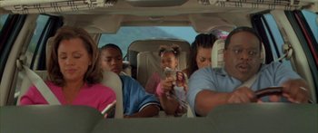 Movie still from “Johnson Family Vacation” (2004), directed by Christopher Erskin – A group of people sitting in the back of a car; Medium shot, High angle