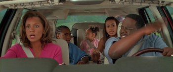 Movie still from “Johnson Family Vacation” (2004), directed by Christopher Erskin – A group of people sitting in the back of a car; Medium shot, High angle