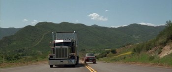 Movie still from “Johnson Family Vacation” (2004), directed by Christopher Erskin – A truck and a car driving down a road; Extreme Wide shot, Low angle