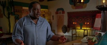 Movie still from “Johnson Family Vacation” (2004), directed by Christopher Erskin – A man standing in front of a table in a room; Medium shot, Low angle