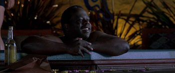 Movie still from “Johnson Family Vacation” (2004), directed by Christopher Erskin – A man smiling and leaning on a bench; Close Up shot, Low angle