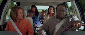 Movie still from “Johnson Family Vacation” (2004), directed by Christopher Erskin – A group of people sitting in the back of a car; Medium shot, High angle