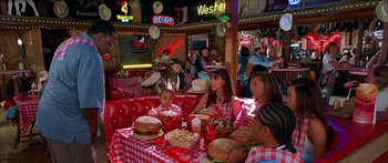 Movie still from “Johnson Family Vacation” (2004), directed by Christopher Erskin – A group of people sitting at a table with food on it; Medium shot, High angle
