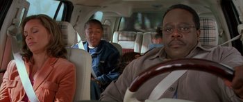 Movie still from “Johnson Family Vacation” (2004), directed by Christopher Erskin – A man and a boy in the back seat of a car; Close Up shot, High angle