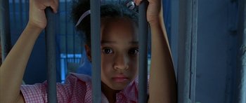 Movie still from “Johnson Family Vacation” (2004), directed by Christopher Erskin – A little girl holding onto a metal fence; Close Up shot, High angle