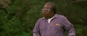 Movie still from “Johnson Family Vacation” (2004), directed by Christopher Erskin – An older man wearing a purple shirt and glasses smoking a cigarette; Close Up shot, Low angle