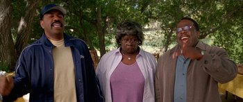 Movie still from “Johnson Family Vacation” (2004), directed by Christopher Erskin – A woman standing next to two other people; Medium shot, High angle