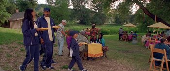 Movie still from “Johnson Family Vacation” (2004), directed by Christopher Erskin – A group of people standing around a picnic table; Wide shot, High angle