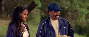 Movie still from “Johnson Family Vacation” (2004), directed by Christopher Erskin – A man and a woman are standing in a park; Medium shot, Over the shoulder angle