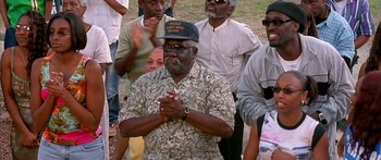 Movie still from “Johnson Family Vacation” (2004), directed by Christopher Erskin – A group of people standing around a field; Medium shot, High angle