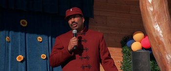 Movie still from “Johnson Family Vacation” (2004), directed by Christopher Erskin – A man in a red jacket is holding a microphone; Medium shot, Over the shoulder angle