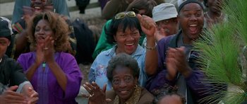 Movie still from “Johnson Family Vacation” (2004), directed by Christopher Erskin – A group of older women and a young man are clapping and smiling; Close Up shot, High angle