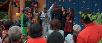 Movie still from “Johnson Family Vacation” (2004), directed by Christopher Erskin – A group of people standing in front of a blue curtain; Medium shot, High angle