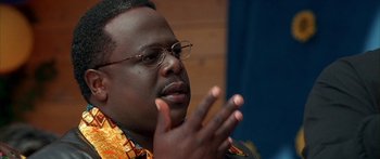 Movie still from “Johnson Family Vacation” (2004), directed by Christopher Erskin – A person wearing glasses and holding his hands up; Close Up shot, Over the shoulder angle