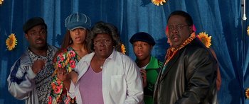 Movie still from “Johnson Family Vacation” (2004), directed by Christopher Erskin – A group of people standing next to each other in a room; Medium shot, High angle