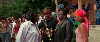 Movie still from “Johnson Family Vacation” (2004), directed by Christopher Erskin – A group of people standing next to each other holding trophies; Medium shot, High angle