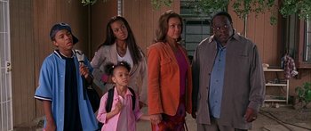 Movie still from “Johnson Family Vacation” (2004), directed by Christopher Erskin – A group of people standing next to each other holding hands; Medium shot, High angle
