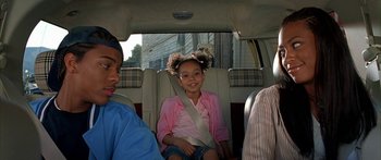 Movie still from “Johnson Family Vacation” (2004), directed by Christopher Erskin – A little girl sitting in the back seat of a car; Medium shot, Over the shoulder angle