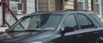 Movie still from “King Jack” (2015), directed by Felix Thompson – A car parked in front of a house with its door ajar; Medium shot, Low angle