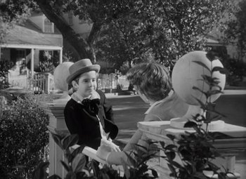 Movie still from “Kings Row” (1942), directed by Sam Wood – A man and a woman are standing in front of a tree; Medium shot, Over the shoulder angle