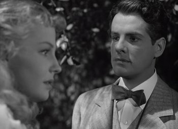 Movie still from “Kings Row” (1942), directed by Sam Wood – A man and a woman standing next to each other in front of a tree; Close Up shot, Low angle