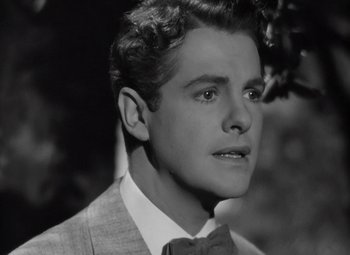 Movie still from “Kings Row” (1942), directed by Sam Wood – A young man in a suit and bow tie; Close Up shot, Low angle