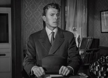 Movie still from “Kings Row” (1942), directed by Sam Wood – A black and white photo of a man in a suit and tie; Medium shot, Low angle