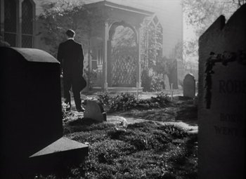 Movie still from “Kings Row” (1942), directed by Sam Wood – A man standing in front of a gazebo in a cemetery; Wide shot, Low angle