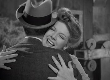Movie still from “Kings Row” (1942), directed by Sam Wood – An old photo of a man and woman hugging; Medium shot, High angle