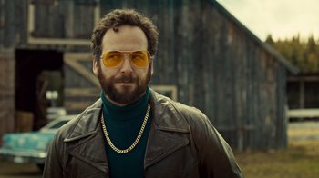 Movie still from “Fargo” (2014), created by Noah Hawley – A man wearing a leather jacket and yellow sunglasses; Close Up shot, Low angle