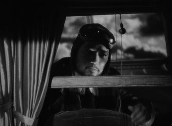 Movie still from “Lost Horizon” (1937), directed by Frank Capra – A man looking out of a window at a cloudy sky; Medium shot, Low angle