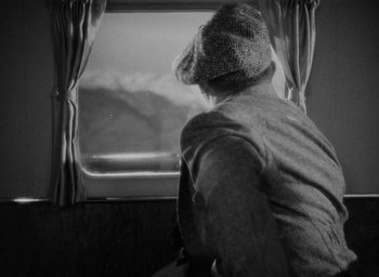 Movie still from “Lost Horizon” (1937), directed by Frank Capra – A person looking out of a window on a train; Medium shot, High angle