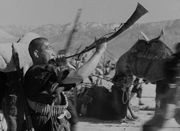Movie still from “Lost Horizon” (1937), directed by Frank Capra – An old photo of a man holding a rifle in his mouth; Medium shot, Low angle