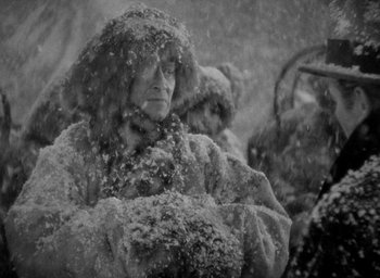 Movie still from “Lost Horizon” (1937), directed by Frank Capra – An old woman is standing in the snow; Medium shot, High angle