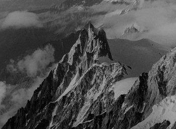 Movie still from “Lost Horizon” (1937), directed by Frank Capra – A black - and - white photo of a snowy mountain; Extreme Wide shot, High angle