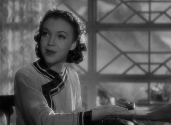Movie still from “Lost Horizon” (1937), directed by Frank Capra – An old black and white photo of a woman sitting at a table; Close Up shot, Over the shoulder angle