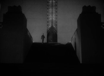 Movie still from “Lost Horizon” (1937), directed by Frank Capra – A man standing on top of a set of stairs; Extreme Wide shot, Low angle