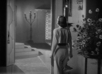 Movie still from “Lost Horizon” (1937), directed by Frank Capra – A black and white photo of a woman walking down the hall way; Wide shot, Low angle