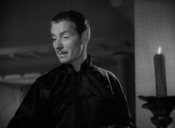 Movie still from “Lost Horizon” (1937), directed by Frank Capra – A black and white photo of a man in a black shirt; Close Up shot, Low angle