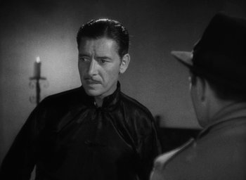 Movie still from “Lost Horizon” (1937), directed by Frank Capra – A black and white photo of a man talking to another man; Medium shot, Over the shoulder angle