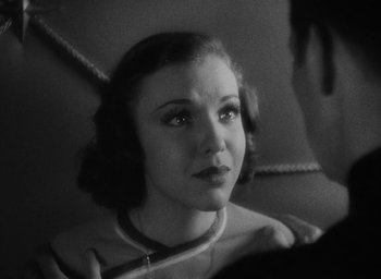Movie still from “Lost Horizon” (1937), directed by Frank Capra – A black - and - white photo of a woman with headphones; Close Up shot, Over the shoulder angle