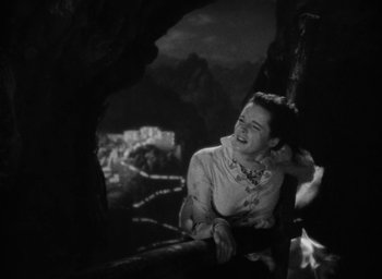 Movie still from “Lost Horizon” (1937), directed by Frank Capra – An old photo of a woman in the dark; Medium shot, Low angle