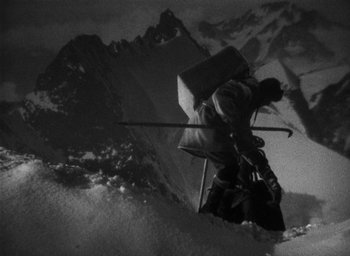 Movie still from “Lost Horizon” (1937), directed by Frank Capra – A man riding skis down the side of a snow covered slope; Wide shot, High angle